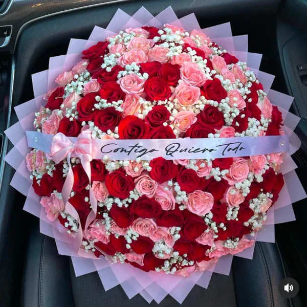 Large bouquet of red and pink roses with baby's breath and a ribbon