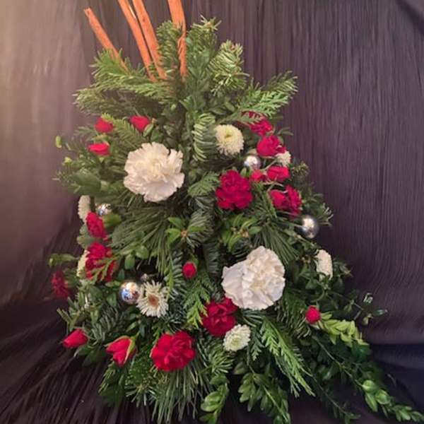 Tall floral arrangement with red and white blooms and evergreen foliage
