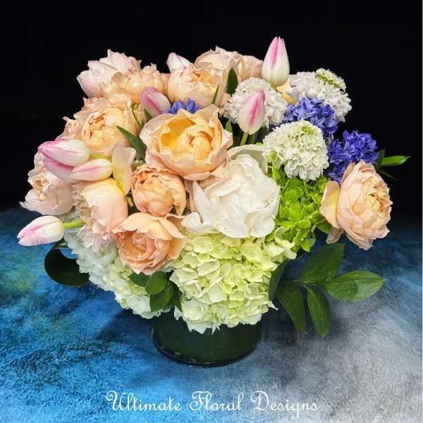 Peach and white roses with pink tulips in a low vase
