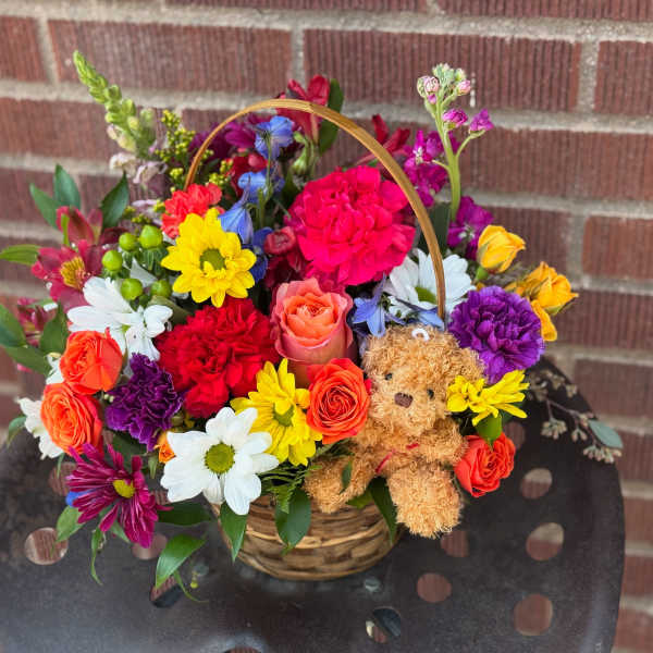 Colorful mixed flower basket with a teddy bear