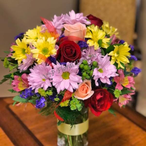 Mixed bouquet of roses and daisies in a glass vase