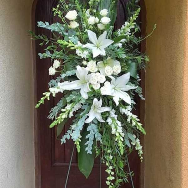 Tall white floral standing spray on an easel