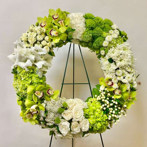 Large green and white floral wreath on a stand
