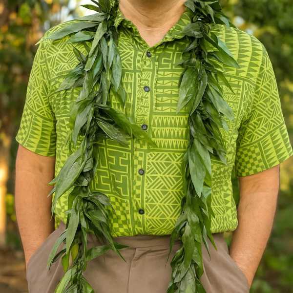 Long green foliage lei draped around a person in a lime patterned shirt