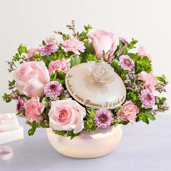 Pink roses and carnations arranged in a round hat box with a mother’s day message
