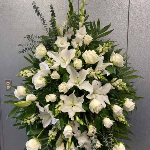 Large white floral standing spray with roses and lilies