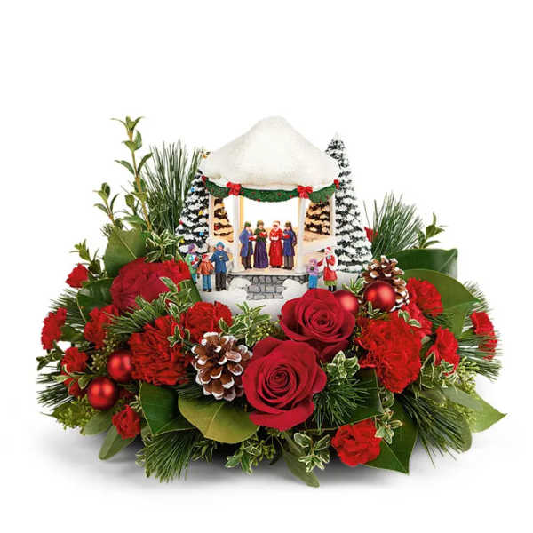 Christmas arrangement with red roses, carnations, and a small gazebo centerpiece
