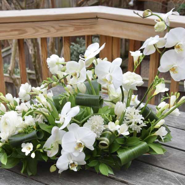 White orchid and mixed white floral arrangement on a table