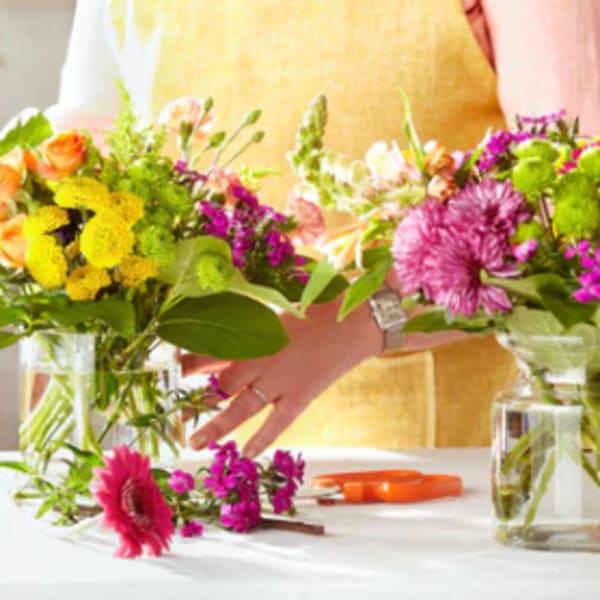 Two colorful flower bouquets in glass vases on a table