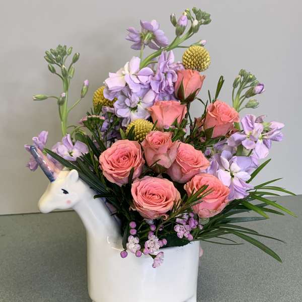 Pink roses and lavender flowers in a unicorn-shaped vase
