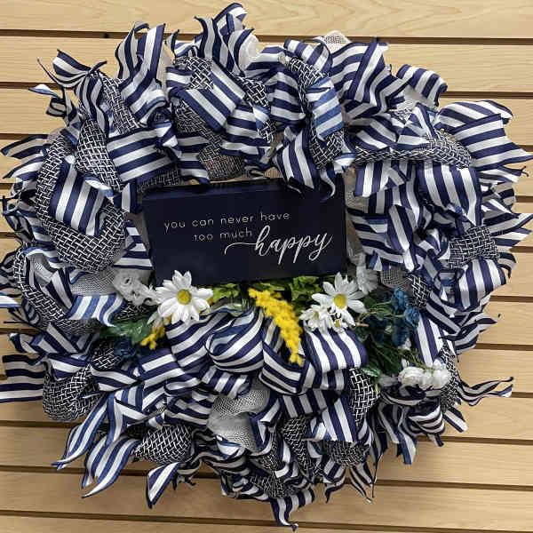 Blue-and-white ribbon wreath with small daisies and a happy sign