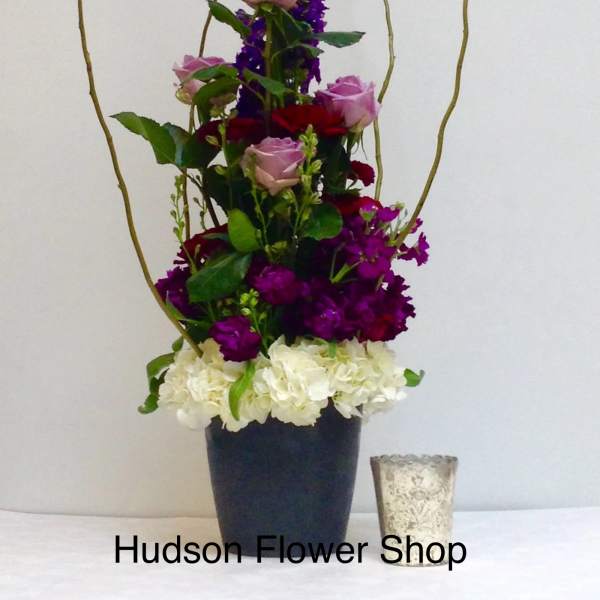 Tall floral arrangement with pink and red roses in a black vase