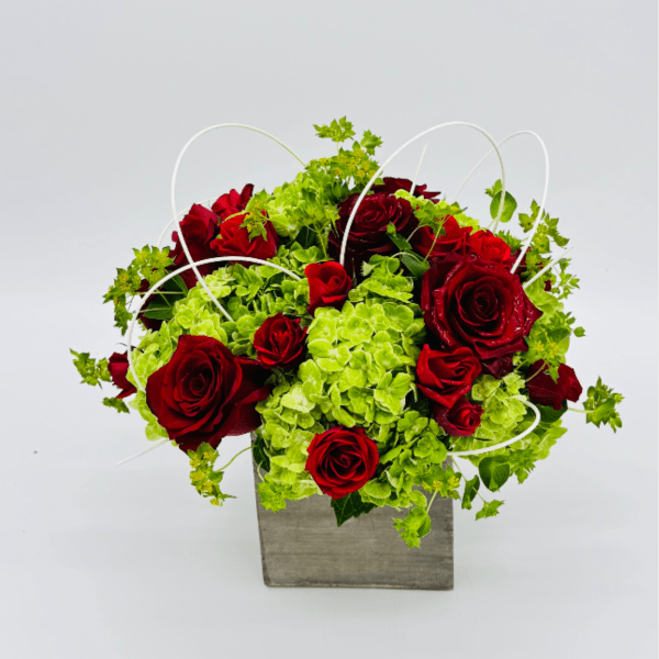 Red roses and green hydrangeas in a square gray container