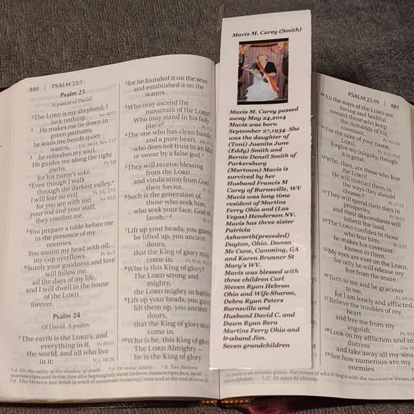 Bible open to Psalms with a memorial bookmark laid across the pages
