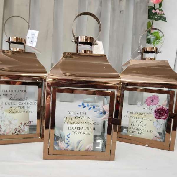 Three rose-gold lanterns with memorial quote inserts