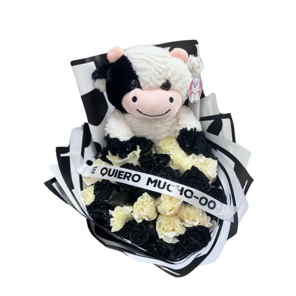 Black and white carnation bouquet with plush cow toy and ribbon reading 'Te quiero mucho-oo'.