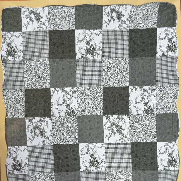 Black-and-white patchwork quilt with floral and checkered squares
