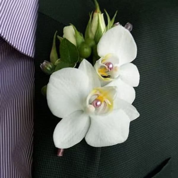 White orchid boutonniere pinned to a dark suit jacket