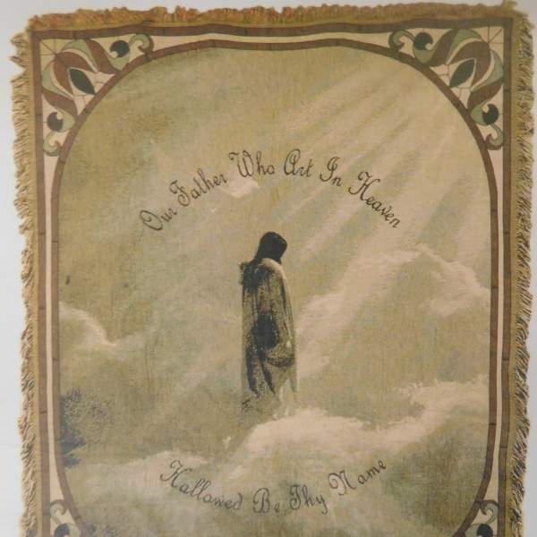 Decorative wall hanging with a robed figure in clouds and cursive text