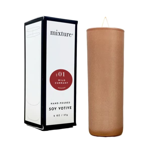 Soy votive candle in a tan holder beside its box