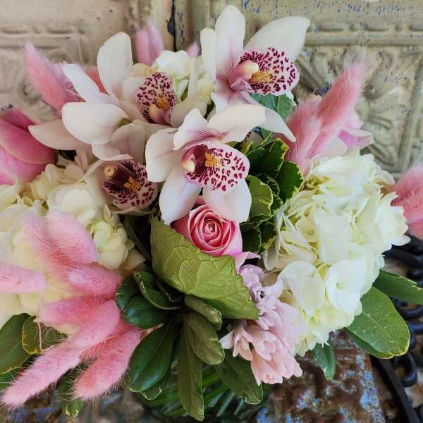 Pink and white bouquet with orchids, roses, hydrangeas, and fluffy pink accents