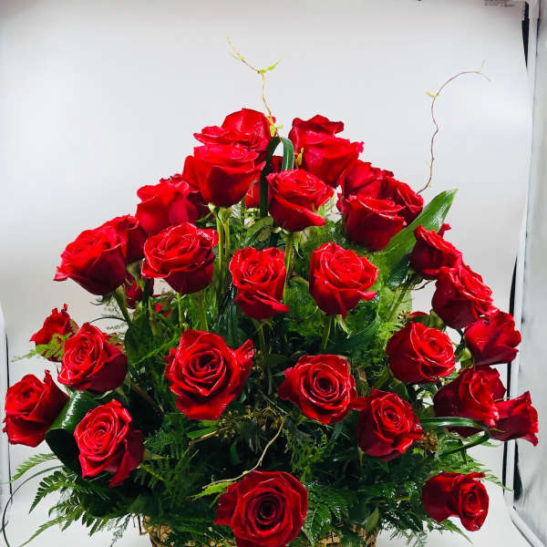 Basket of red roses with greenery