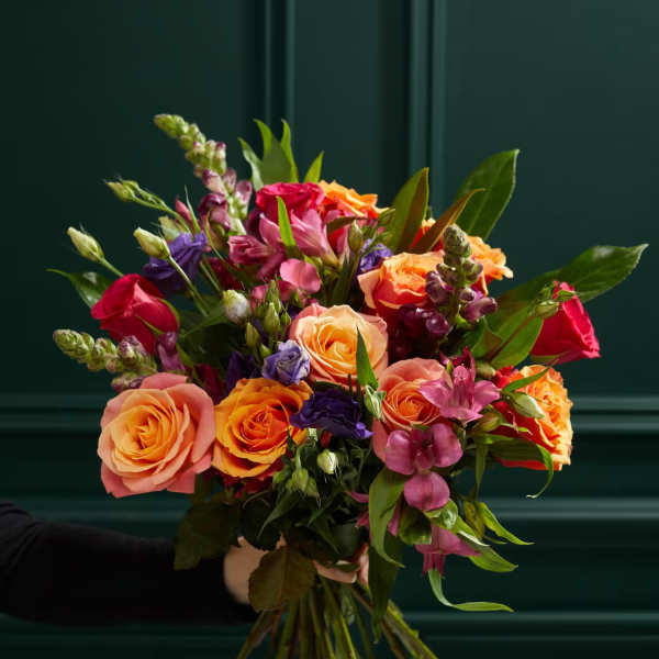 Hand-tied bouquet of orange, pink, and purple flowers