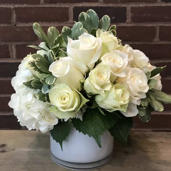White rose arrangement in a white vase