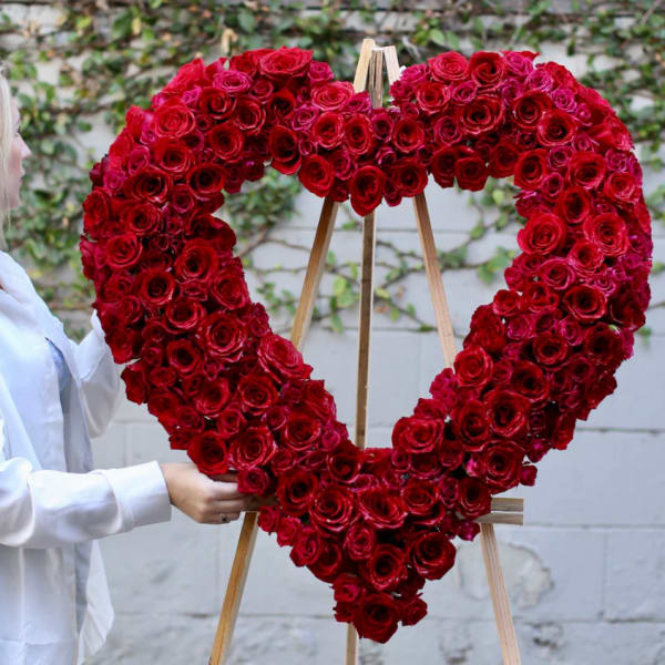 Heart-shaped red rose arrangement on an easel