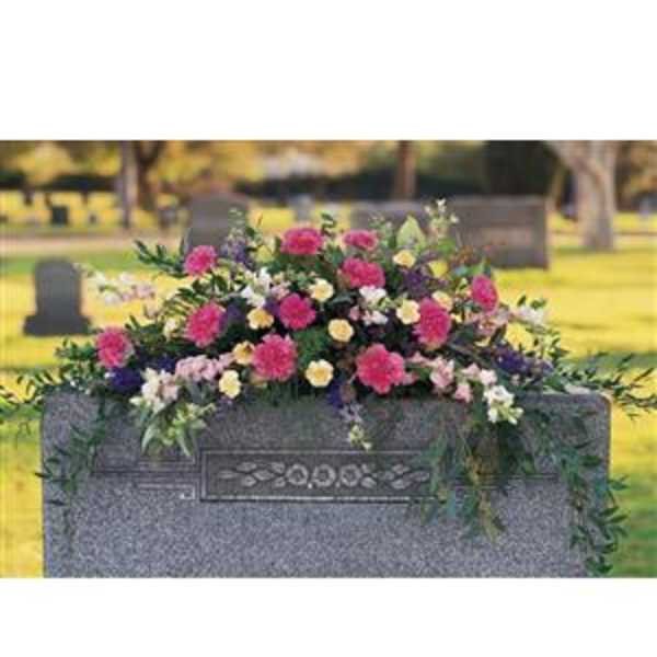 Pink and white floral arrangement on a gravestone