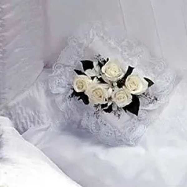 White rose bouquet with black ribbon accents on lace fabric