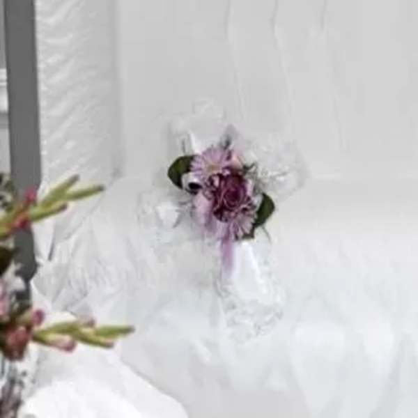 Small purple floral corsage on white fabric