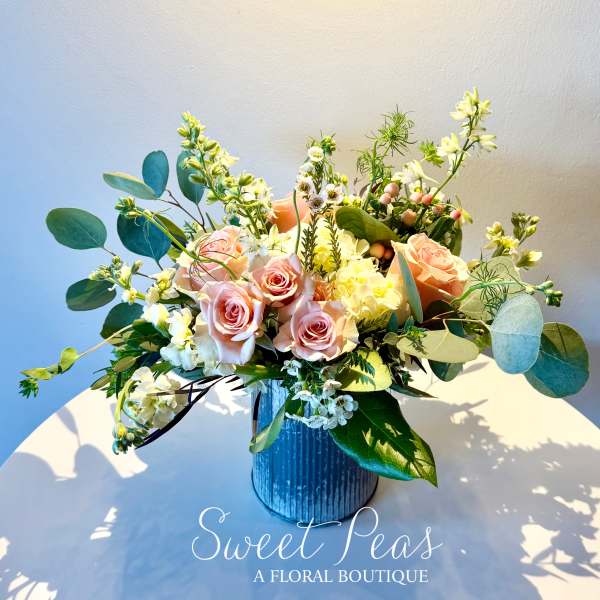 Pink roses and white flowers arranged in a blue vase