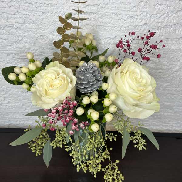 Cream rose arrangement with berries and eucalyptus in a vase