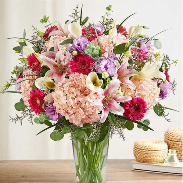 Mixed bouquet of pink and white flowers in a clear glass vase