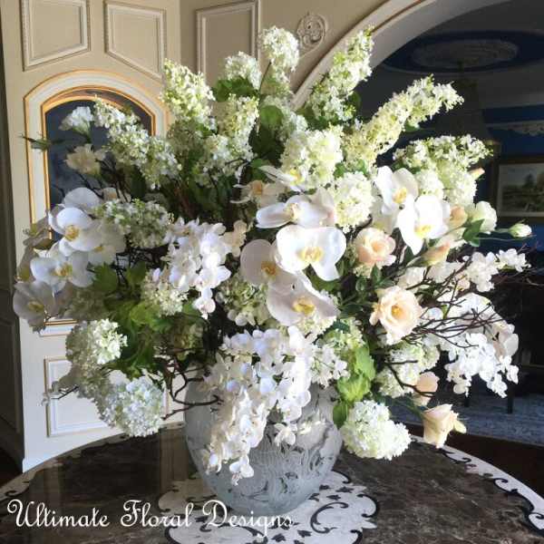 Large white floral arrangement in a decorative vase