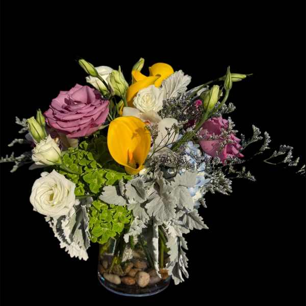 Mixed bouquet of roses, tulips, and lisianthus in a glass vase