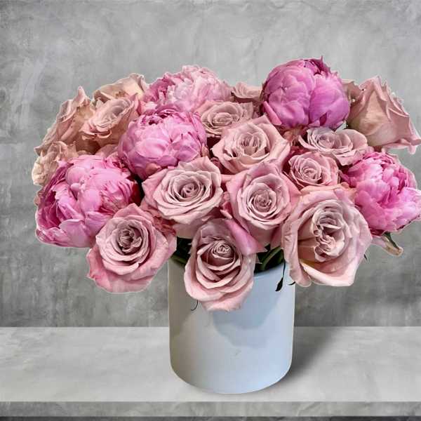 Pink roses and peonies arranged in a white vase
