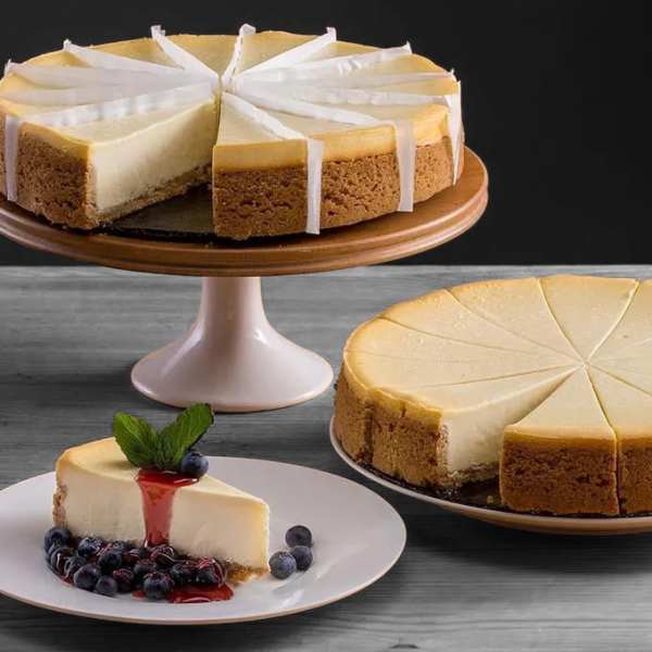 Three cheesecake desserts on plates and a cake stand