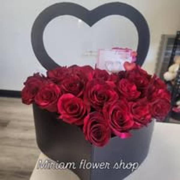 Red roses arranged in a black heart-shaped box