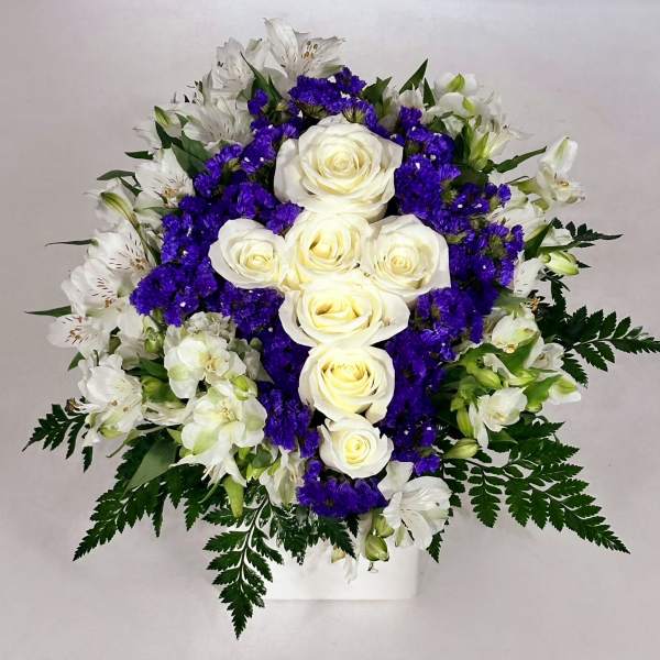 White roses and purple flowers in a white vase