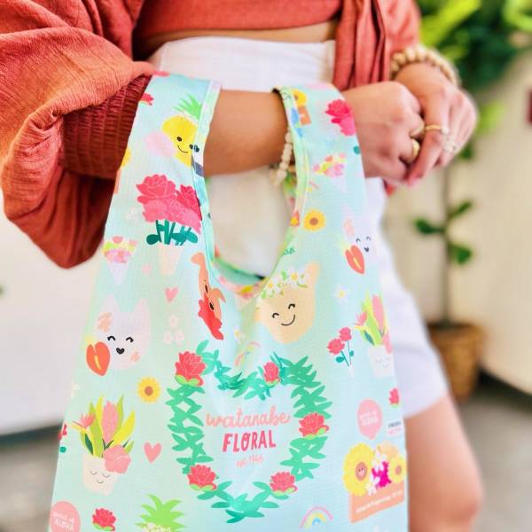 Reusable tote bag with pastel blue background and cheerful floral and fruit cartoons