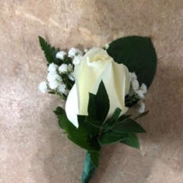 White rose boutonniere with baby's breath and green leaves