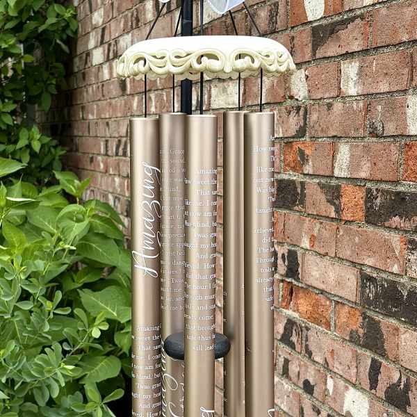 Decorative wind chime with a large white bow and gold tubes