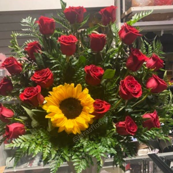 Bouquet of red roses with a yellow sunflower in a vase