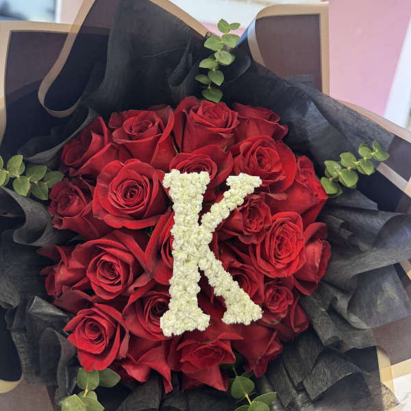 Bouquet of red roses with a white floral letter K