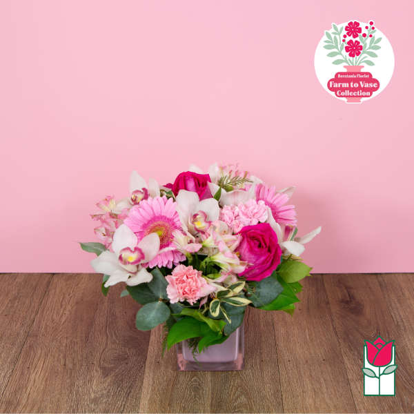 Pink and white mixed flower arrangement in a square glass vase