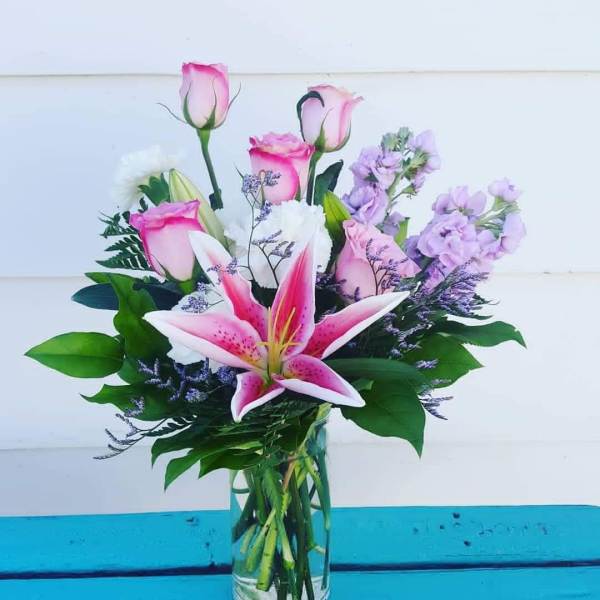 Pink lilies and roses in a clear glass vase