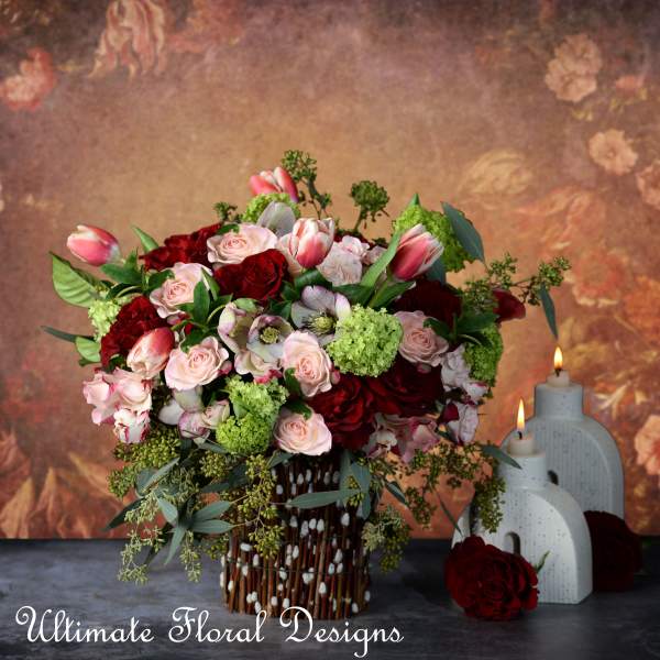 Bouquet of pink and red roses with tulips in a decorative vase