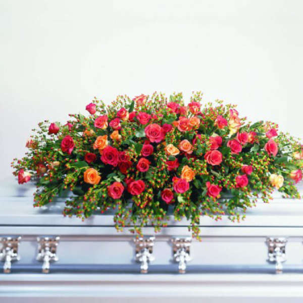 Large spray of pink and orange roses on a casket